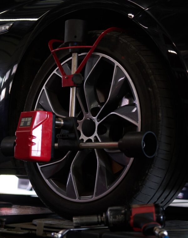 Balancing of car's tyres at auto workshop Closeup photoshoot of process or tyre balancing at dark auto service.