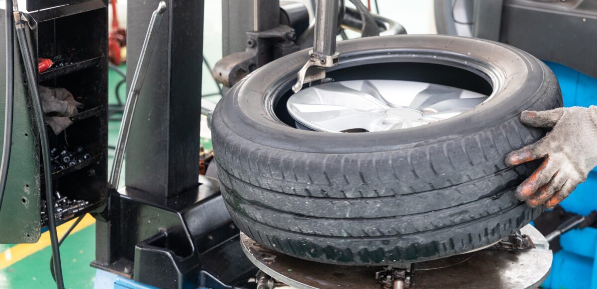 Series of worker removing tire from rim with removal machinery Series of worker removing tire from rim with tire removal machinery equipment