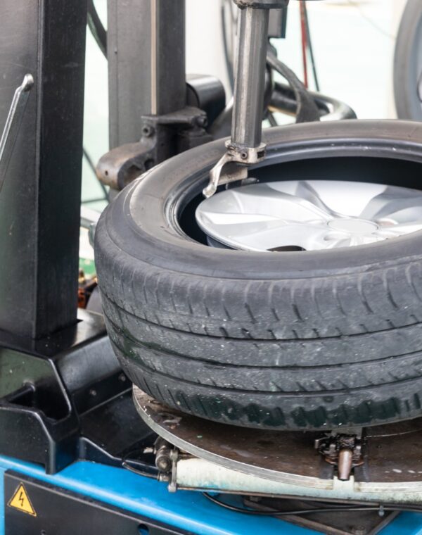 Series of worker removing tire from rim with removal machinery Series of worker removing tire from rim with tire removal machinery equipment