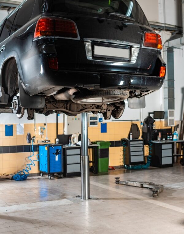 modern black car raised on car lift in workshop modern black car raised on car lift in workshop